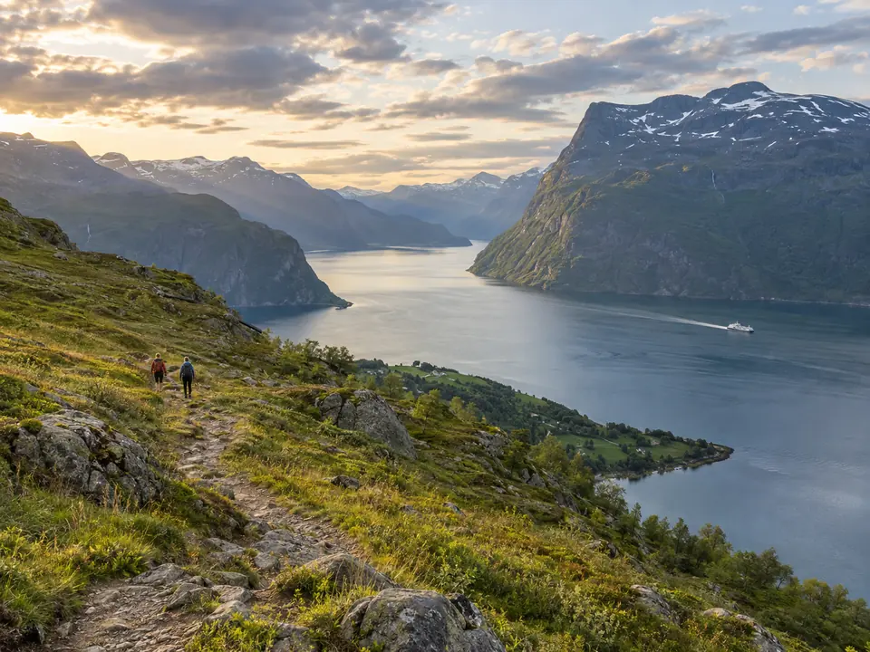 Randonneurs sur un sentier dominant un fjord norvégien
